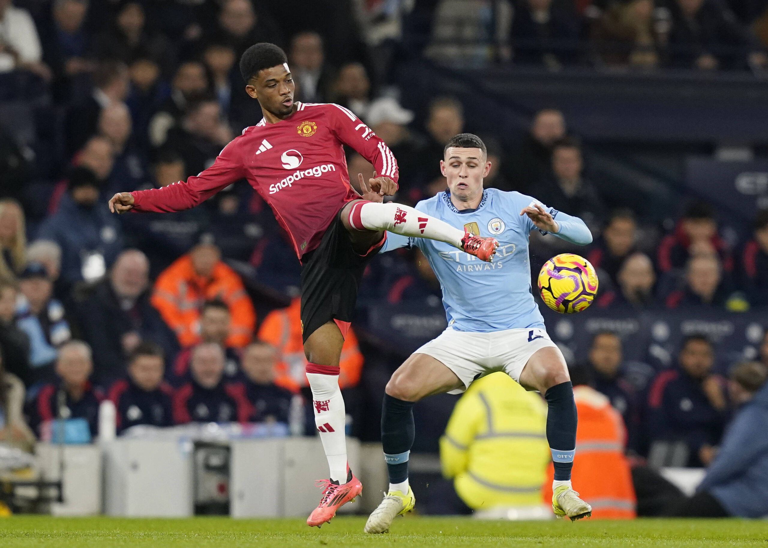 Manchester, England, 15th December 2024. Amad Diallo of Manchester United, ManU tackled by Phil Foden of Manchester City during the Premier League match at the Etihad Stadium, Manchester. Picture credit should read: Andrew Yates / Sportimage EDITORIAL USE ONLY. No use with unauthorised audio, video, data, fixture lists, club/league logos or live services. Online in-match use limited to 120 images, no video emulation. No use in betting, games or single club/league/player publications. SPI-3541-0022