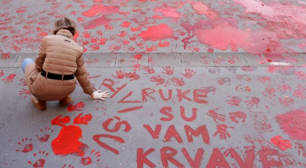 epa11751325 A protestor paints the pavement with red paint symbolizing blood during the one month anniversary of the Novi Sad train station accident in Novi Sad, Serbia, 01 December 2024. Fifteen people lost their lives in the collapse of the Novi Sad Railway Station canopy on 01 November 2024. The station building, which had been renovated and reopened on 05 July 2024, was undergoing further renovations shortly before the collapse.  EPA/ANDREJ CUKIC