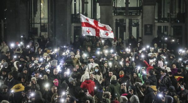 epa11760932 Supporters of the Georgian opposition hold a Georgian flag during a protest in front of the Parliament building in Tbilisi, Georgia, 06 December 2024. Thousands of pro-EU activists continue their protests in the Georgian capital against the country's ruling party decision to suspend accession talks with the European Union (EU) until the end of 2028.  EPA/DAVID MDZINARISHVILI