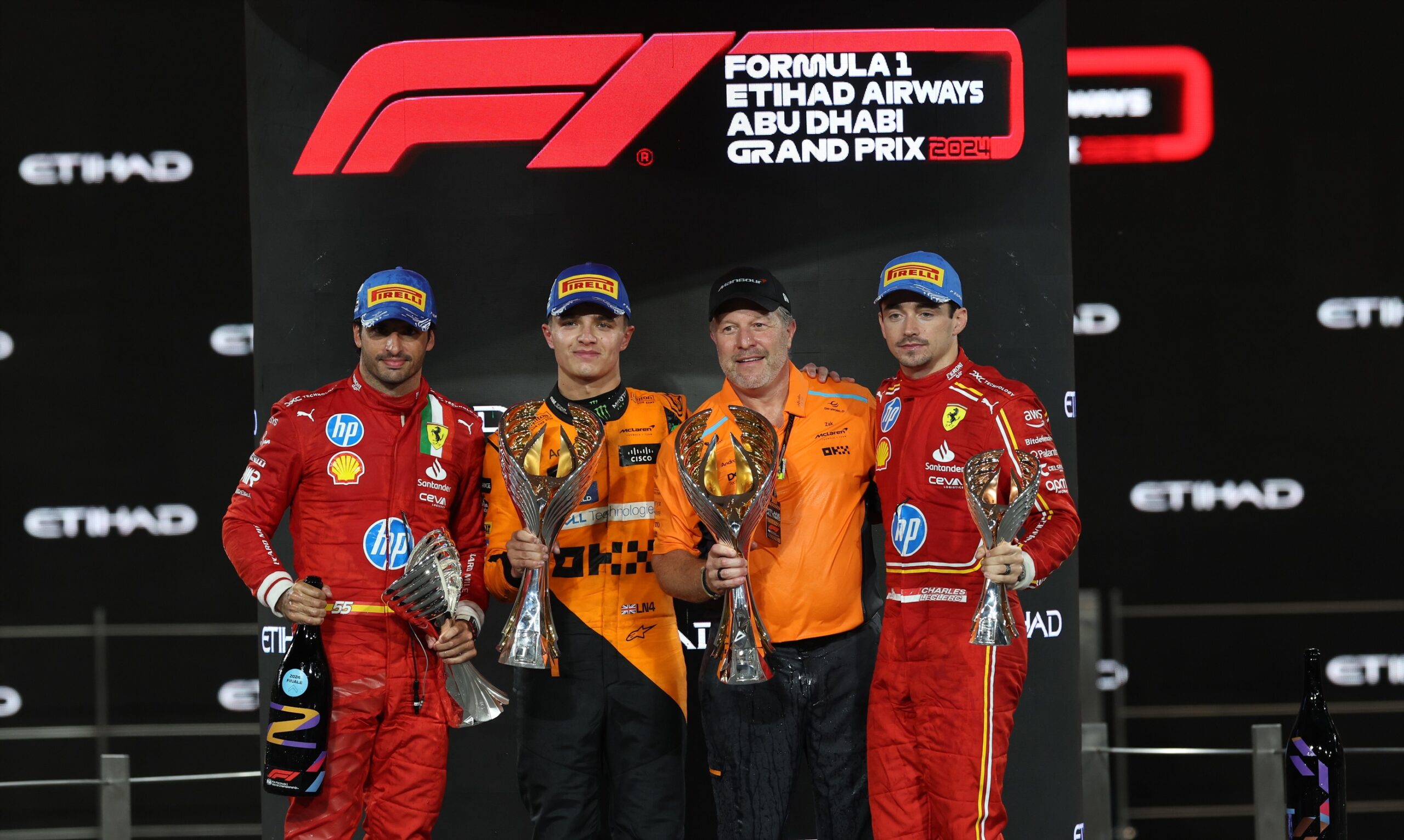epa11764930 (L-R) Second placed Scuderia Ferrari driver Carlos Sainz Jr. of Spain, first placed McLaren driver Lando Norris of Britain, McLaren Racing CEO Zak Brown and third placed Scuderia Ferrari driver Charles Leclerc of Monaco celebrate on the podium after the Formula One Abu Dhabi Grand Prix, at the Yas Marina Circuit racetrack in Abu Dhabi, United Arab Emirates, 08 December 2024.  EPA/ALI HAIDER