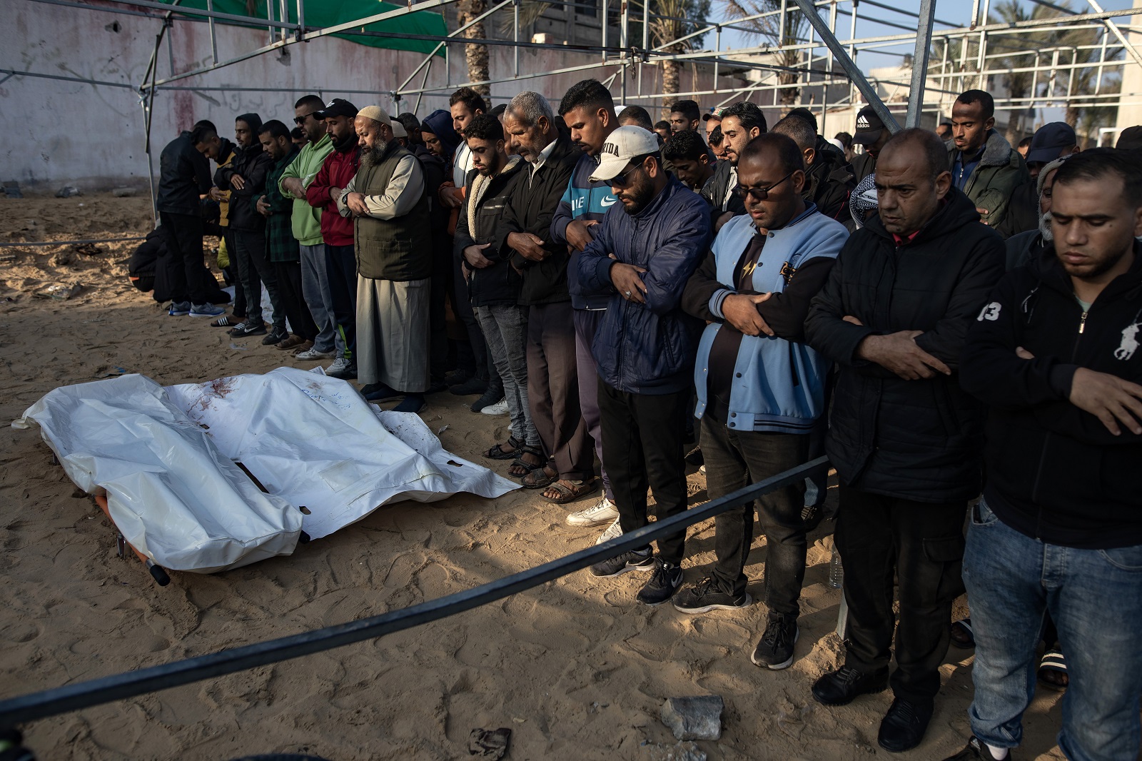epa11771770 Palestinians pray in front of the bodies of their relatives who were killed in an Israeli airstrike, west of Khan Younis in the southern Gaza Strip, 12 December 2024. According to Nasser Hospital in Gaza, more than 12 Palestinians guarding humanitarian aid were killed in an Israeli airstrike west of Khan Younis. More than 45,000 Palestinians and over 1,400 Israelis have been killed, according to the Palestinian Health Ministry and the Israeli Army, since Hamas militants launched an attack against Israel from the Gaza Strip on 07 October 2023, and the Israeli operations in Gaza and the West Bank which followed it.  EPA/HAITHAM IMAD