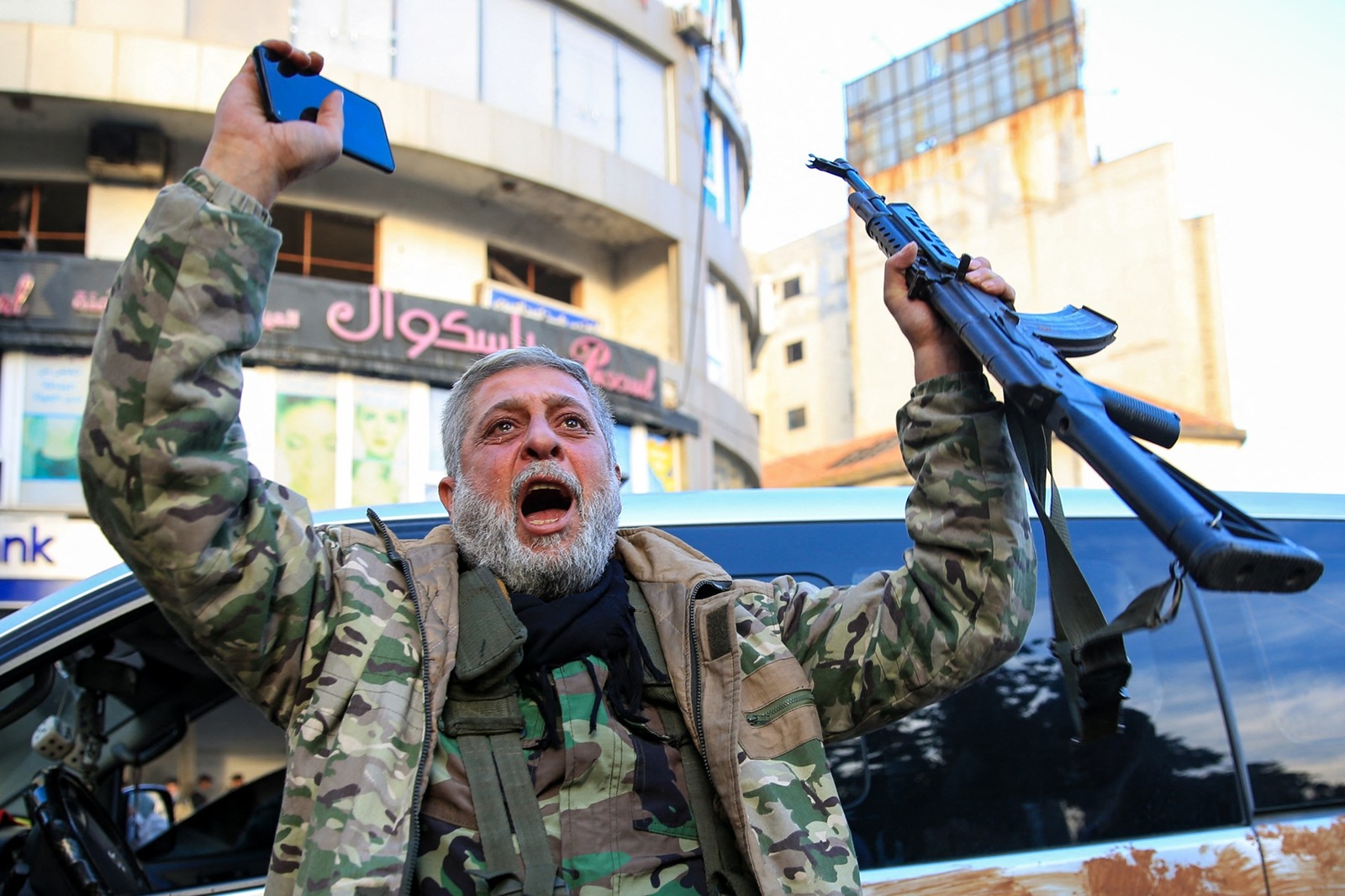 A Syrian rebel fighter who returned to the central city of Homs on December 8, 2024, after being in exile for 12 years celebrates after rebel forces entered Syria's third city overnight. Islamist-led rebels declared that they have taken Damascus in a lightning offensive on December 8, sending President Bashar al-Assad fleeing and ending five decades of Baath rule in Syria.,Image: 944295688, License: Rights-managed, Restrictions: , Model Release: no, Credit line: Aref TAMMAWI / AFP / Profimedia