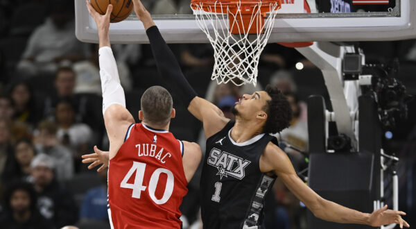 San Antonio Spurs' Victor Wembanyama (1) blocks a shot by Los Angeles Clippers' Ivica Zubac during the first half of an NBA basketball game, Tuesday, Dec. 31, 2024, in San Antonio. (AP Photo/Darren Abate)