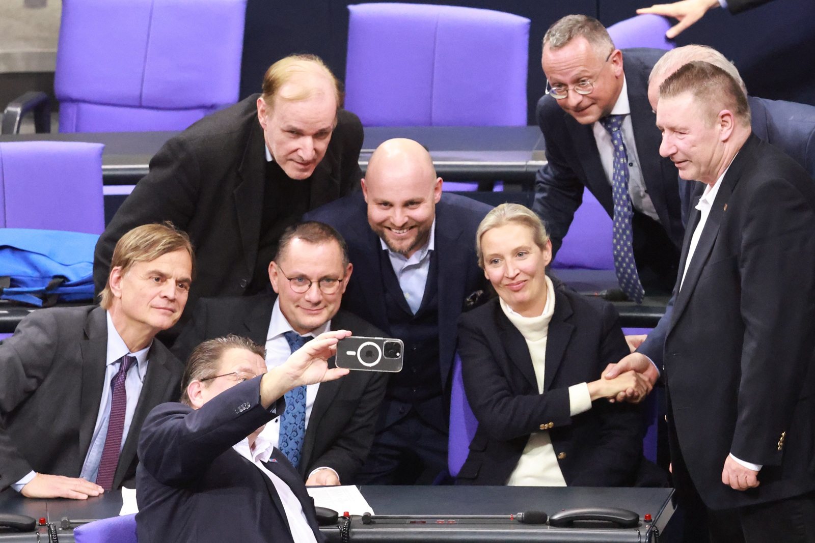 epa11860958 Alternative for Germany (AfD) party Members of Parliament stand around Alternative for Germany (AfD) party and faction co-chairwoman Alice Weidel (C-R) and Alternative for Germany (AfD) party and faction co-chairman Tino Chrupalla (C-L) as they pose for a selfie after a motion of the Christian Democratic Union (CDU) won a majority during a session of the German parliament 'Bundestag' in Berlin, Germany, 29 January 2025. One of the main topics of session of the Bundestag is the delivery of a government statement by German Chancellor Olaf Scholz on current domestic policy issues.  EPA/CLEMENS BILAN