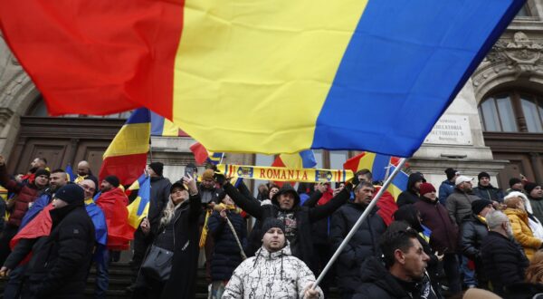 epa11799300 Supporters of independent candidate Calin Georgescu (not pictured) wave Romanian national flags as they gather on the steps of the Bucharest Court of Appeal headquarters in Bucharest, Romania, 30 December 2024. Georgescu, winner of the first round of the annulled presidential elections, filed a lawsuit challenging the Central Electoral Bureau's annulment of the entire electoral process and the resumption of the presidential elections, based on the Romanian Constitutional Court's ruling, and pressed charges against several prominent political figures and institutions in Romania.  EPA/BOGDAN CRISTEL