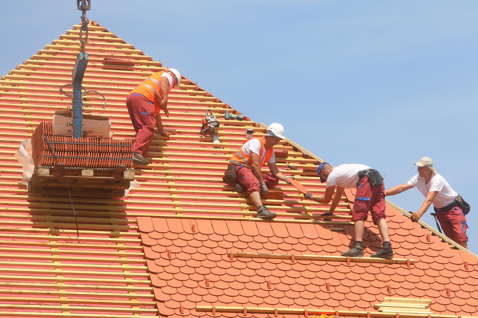20.06.2023., Karlovac - Usprkos jakom suncu i visokim temperaturama radnici postavljaju crijep na krov zgrade u Zvijezdi. Photo: Kristina Stedul Fabac/PIXSELL