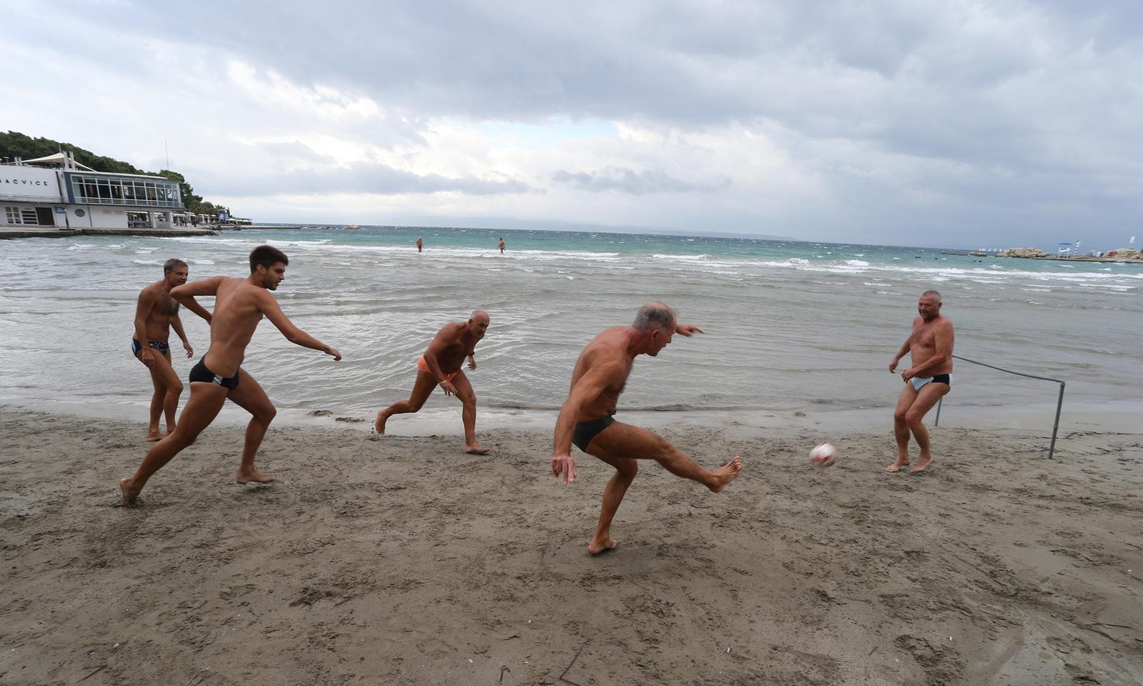 08.10.2013., Split - Kisno vrijeme mnogima je pokvarilo praznicni ugodjaj, ali ne i skupini nogometasa koji su zabavu pronasli u plicaku i pjesku splitskih Bacvica.rPhoto: Ivo Cagalj/PIXSELL