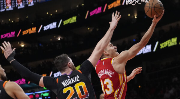 Atlanta Hawks guard Bogdan Bogdanovic (13) drives past Phoenix Suns center Jusuf Nurkic (20) as hscores a basket in the first half of an NBA basketball game Friday, Feb. 2, 2024, in Atlanta. (AP Photo/John Bazemore)