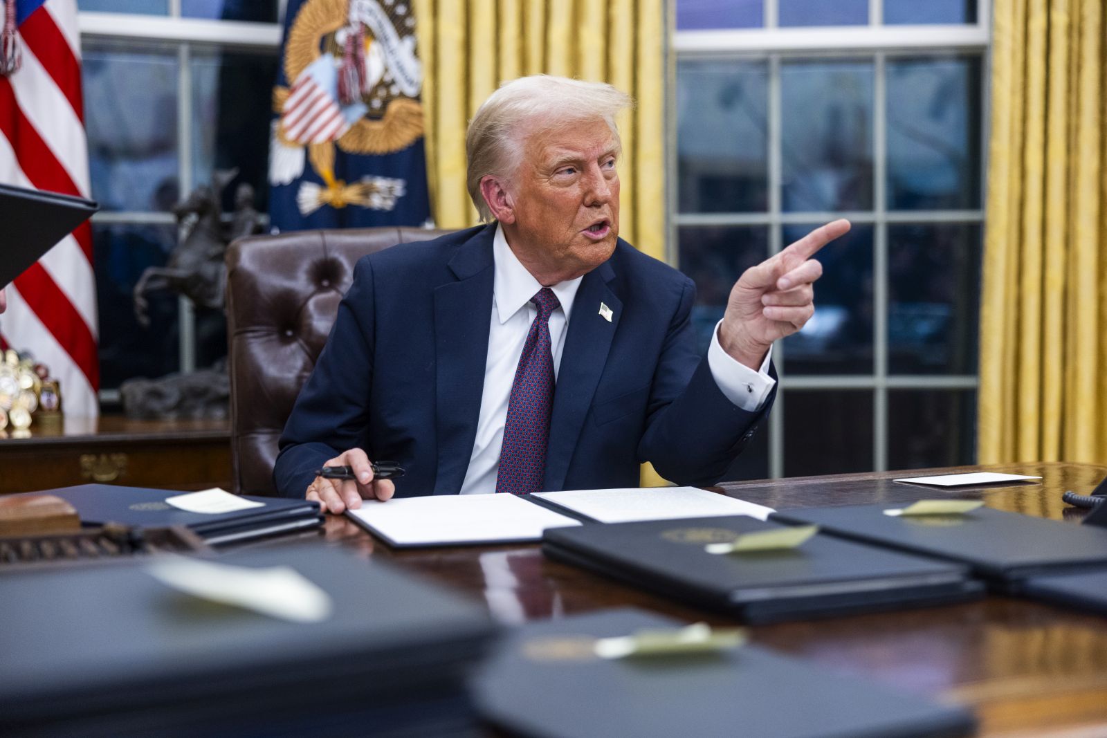 epa11840839 US President Donald Trump signs numerous executive orders, including pardons for defendants from the January 6th riots and a delay on the TikTok ban, on the first day of his presidency in the Oval Office of the White House in Washington, DC, USA, 20 January 2025. Trump, who defeated Kamala Harris to become the 47th president of the United States, was sworn in earlier in the day, though the planned outdoor ceremonies and events were cancelled due to extremely cold temperatures.  EPA/JIM LO SCALZO / POOL