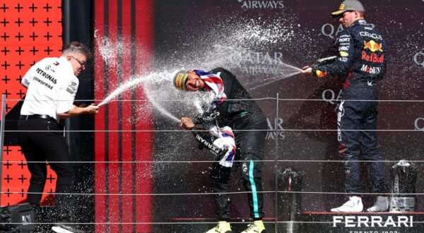 Formula One F1 - British Grand Prix - Silverstone Circuit, Silverstone, Britain - July 7, 2024 Mercedes' Lewis Hamilton celebrates on the podium with champagne and Mercedes senior race engineer Peter Bonnington on the podium after winning the British Grand Prix and second place Red Bull's Max Verstappen REUTERS/Andrew Boyers Photo: Andrew Boyers/REUTERS