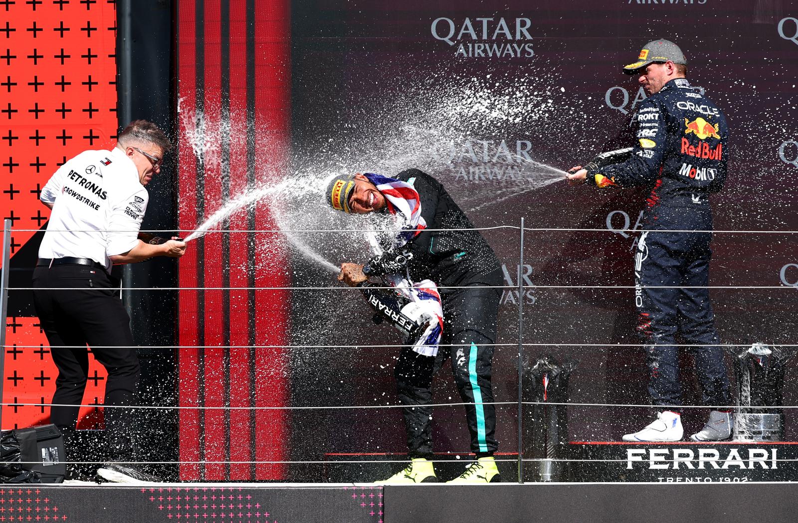 Formula One F1 - British Grand Prix - Silverstone Circuit, Silverstone, Britain - July 7, 2024 Mercedes' Lewis Hamilton celebrates on the podium with champagne and Mercedes senior race engineer Peter Bonnington on the podium after winning the British Grand Prix and second place Red Bull's Max Verstappen REUTERS/Andrew Boyers Photo: Andrew Boyers/REUTERS