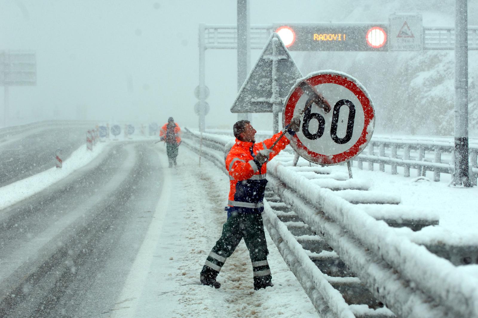24.03.2009., Rijeka - Veliki snijeg i snjezna mecava na autocesti Rijeka-Zagreb. Radnici ciste prometnu signalizaciju. r"nPhoto: Goran Kovacic/Vecernji list