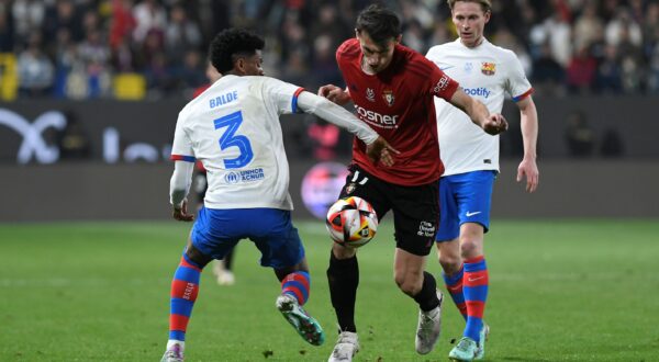 Barcelona's Alejandro Balde, left, fights for the ball with Osasuna's Ante Budimir, center, during the Spanish Super Cup semi final soccer match between Osasuna and Barcelona at Al Awal Park Stadium in Riyadh, Saudi Arabia, Thursday, Jan. 11, 2024. (AP Photo) Saudi Spain Soccer Super Cup