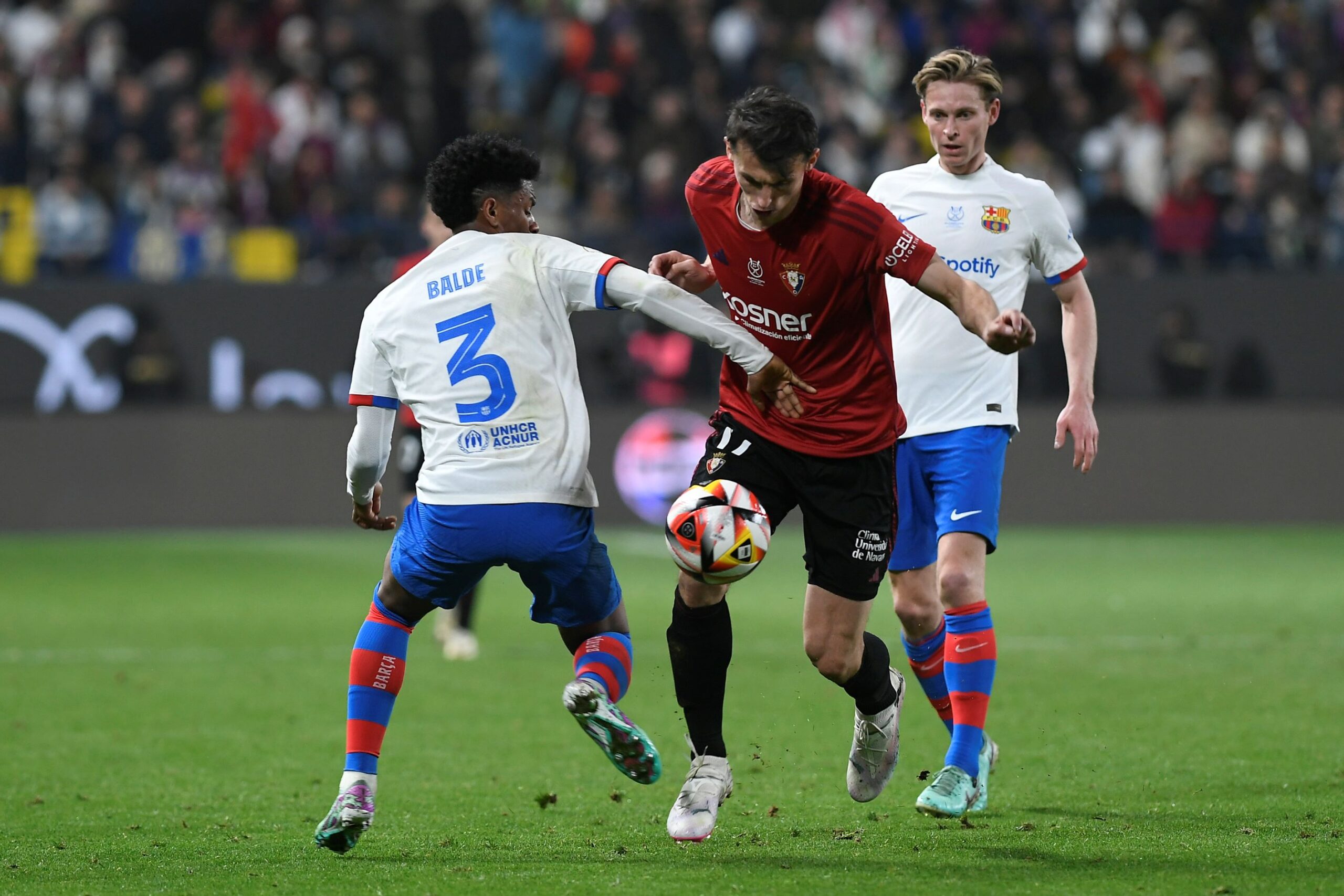 Barcelona's Alejandro Balde, left, fights for the ball with Osasuna's Ante Budimir, center, during the Spanish Super Cup semi final soccer match between Osasuna and Barcelona at Al Awal Park Stadium in Riyadh, Saudi Arabia, Thursday, Jan. 11, 2024. (AP Photo) Saudi Spain Soccer Super Cup