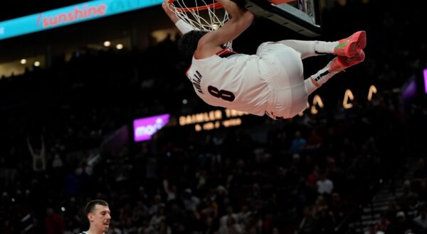Portland Trail Blazers forward Deni Avdija (8) hold on to the basket after dunking during the second half of an NBA basketball game against the Denver Nuggets, Friday, March 21, 2025, in Portland, Ore. (AP Photo/Jenny Kane) Nuggets Trail Blazers Basketball