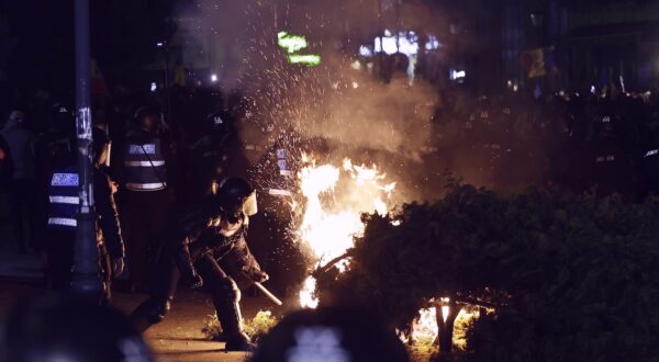 epa11952860 A riot-policeman tries to extinguish a street decoration set on fire by protesters while his colleagues scuffle with Calin Georgescu's supporters during a protest that turned violent in front of Central Elections Bureau (BEC) after Georgescu's candidacy was invalidated, in Bucharest, Romania, late 09 March 2025. Calin Georgescu, the independent candidate who won the first round of Romania's annulled presidential elections, registered his candidacy at Central Elections Bureau on Friday 07 March 2025. Former independent presidential candidate Calin Georgescu was questioned by prosecutors on 26 February 2025 as part of an investigation into election campaign fraud, including actions against the constitutional order and false statements about campaign financing. A judge from the Prosecutor General's Office imposed a judicial control measure, which Georgescu appealed. Romanians will vote in the first round of the presidential elections on 4 May 2025.  EPA/ROBERT GHEMENT