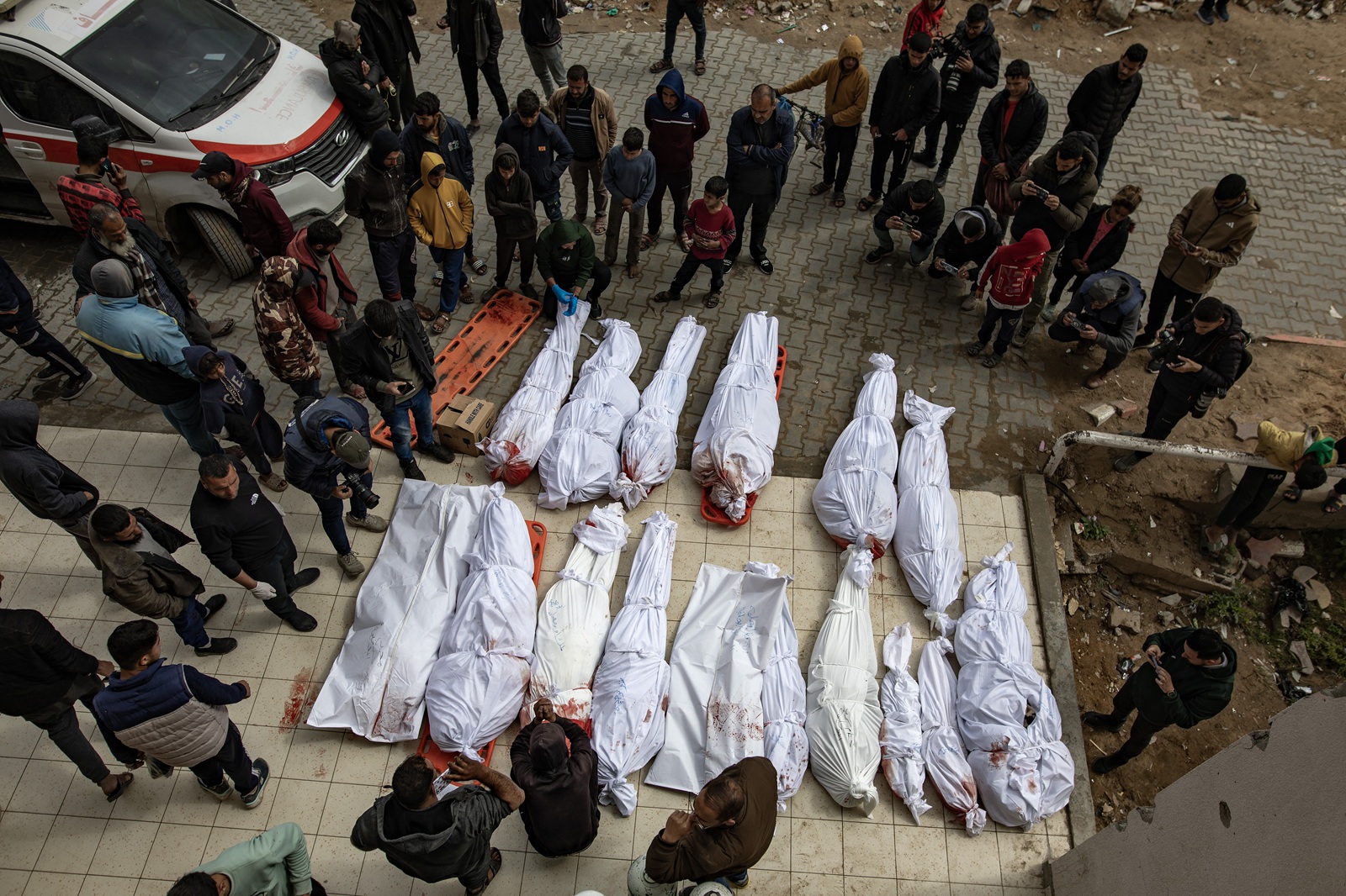 epa11975516 Palestinians stand next to the bodies of relatives killed in overnight Israeli airstrikes in the northern Gaza Strip, outside the Indonesian Hospital in Beit Lahia, 20 March 2025. On 18 March Israeli forces resumed airstrikes on Gaza ending a ceasefire held in place since 19 January and killing over 400 people on the first day, the Health Ministry confirmed.  EPA/HAITHAM IMAD
