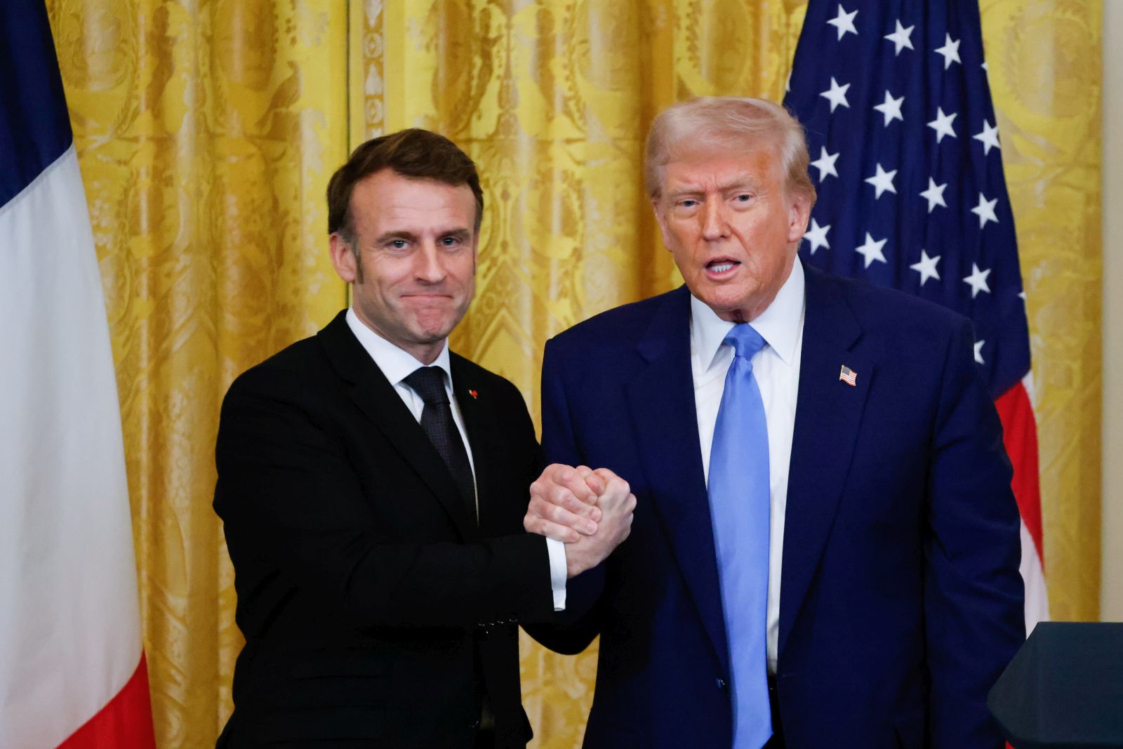 epa11922455 US President Donald Trump (R) and French President Emmanuel Macron (L) shake hands at the end of a joint press conference in the East Room to the White House in Washington, DC, USA, 24 February 2025.  EPA/LUDOVIC MARIN / POOL