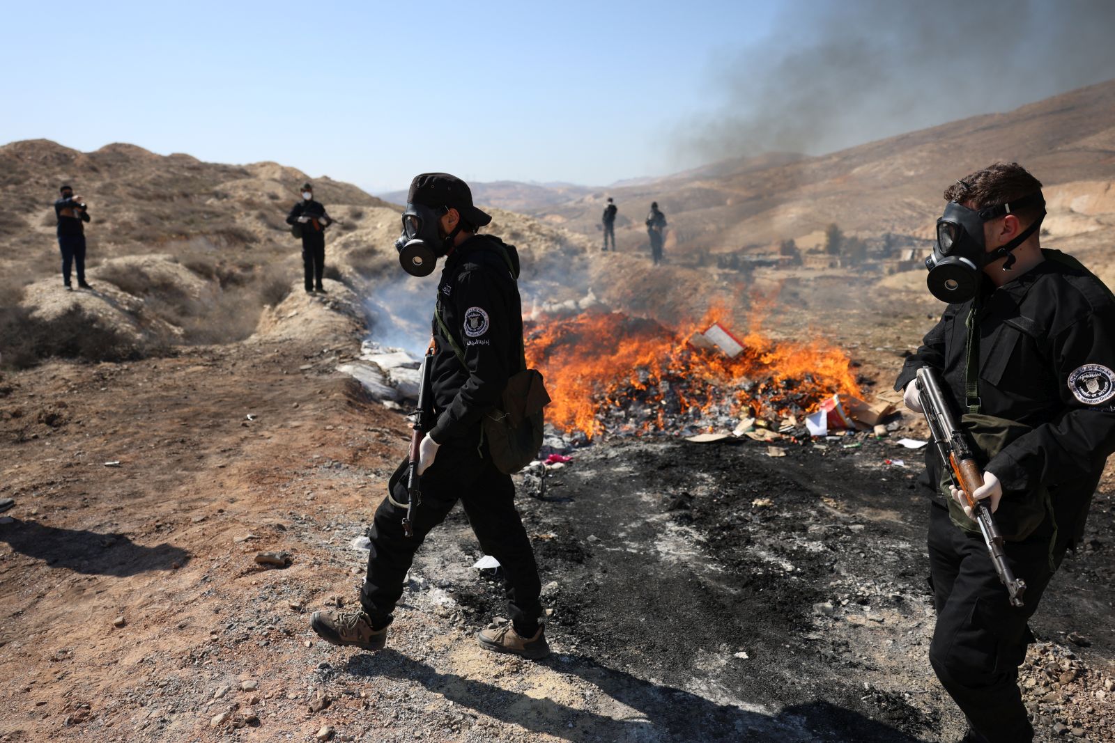 epa11923609 Syrian police officers secure the area as they burn drugs in Damascus, Syria, 25 February 2025. Syria’s new authorities burned hundreds of tons of narcotic pill Captagon as well as bags of hashish, at the headquarters of the fourth division in Damascus.  EPA/MOHAMMED AL RIFAI