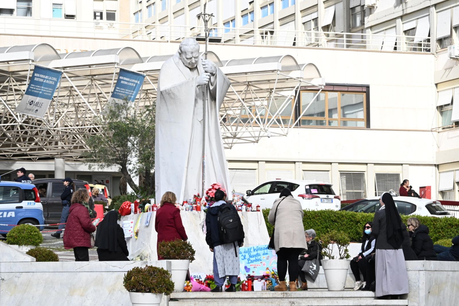 epa11928070 Faithful pray under a statue of Pope St. John Paul II outside the Gemelli University Hospital, where Pope Francis is hospitalized, in Rome, Italy, 27 February 2025. The pontiff was admitted to Rome's Gemelli Hospital on 14 February, due to a respiratory tract infection. His condition has shown a slight improvement over the past couple of days, the Holy See Press Office said on 27 February, adding that the Jubilee Audience scheduled for 01 March, has been cancelled.  EPA/MAURIZIO BRAMBATTI