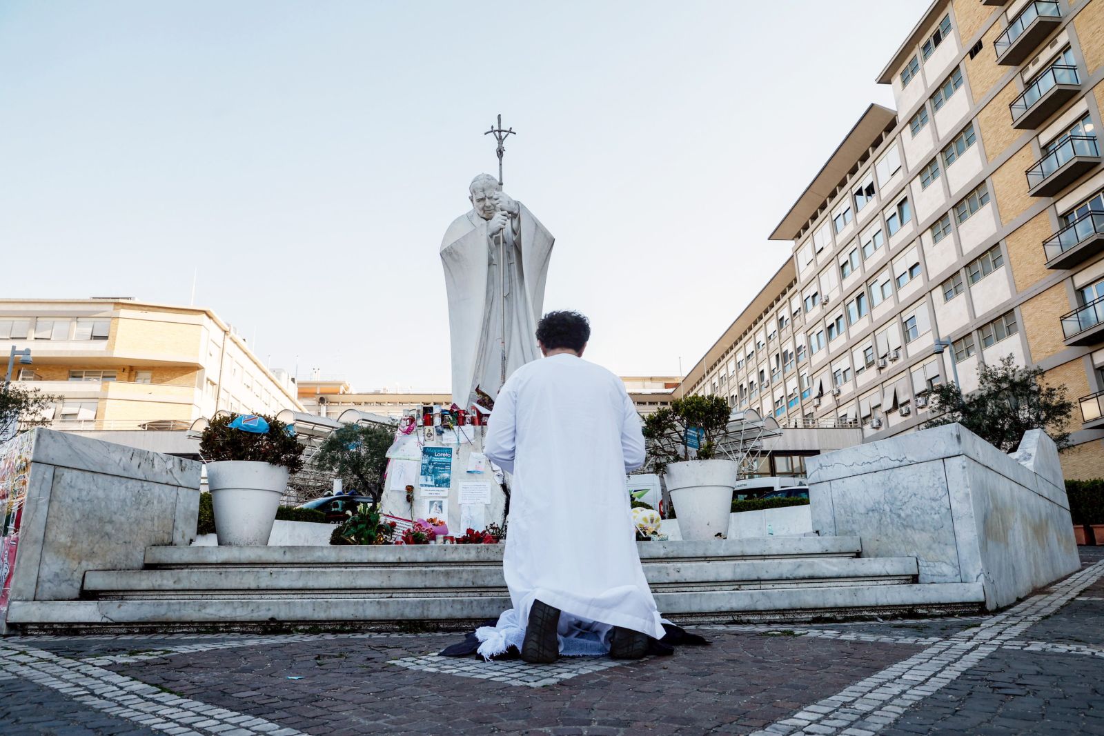 epa11943739 A person prays near the statue of John Paul II outside Agostino Gemelli Hospital where Pope Francis continues his treatments for bilateral pneumonia, in Rome, Italy, 06 March 2025. The pope was admitted to hospital on 14 February due to a respiratory tract infection.  EPA/GIUSEPPE LAMI