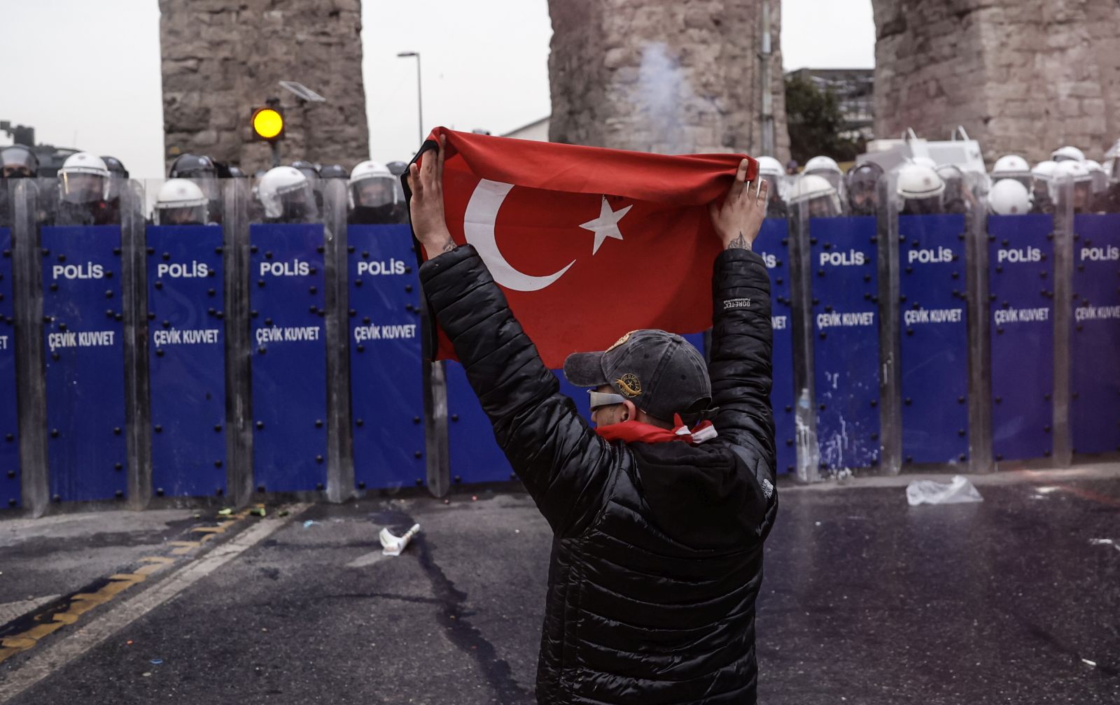 epa11984020 A masked protester confronts Turkish riot police as demonstrators try to march to Taksim Square from the Istanbul Municipality headquarters during a protest against the detention of Istanbul Mayor Ekrem Imamoglu in Istanbul, Turkey, 23 March 2025. Istanbul Mayor Ekrem Imamoglu of the Republican People's Party (CHP) was jailed and dismissed by the Turkish Ministry of Interior on 23 March on corruption charges following his detention on March 19 along with 100 others.  EPA/ERDEM SAHIN