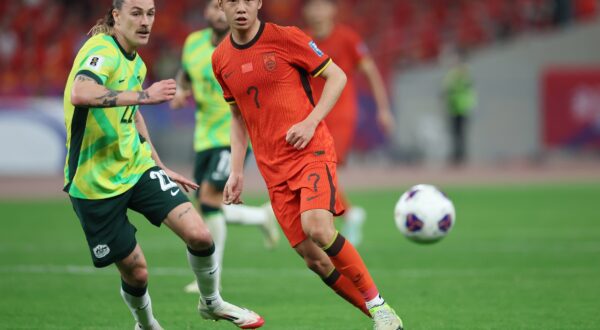 epa11987148 Xu Haoyang (R) of China in action against Jackson Irvine of Australia during the FIFA World Cup 2026 qualification match between China and Australia in Hangzhou, China, 25 March 2025.  EPA/ALEX PLAVEVSKI