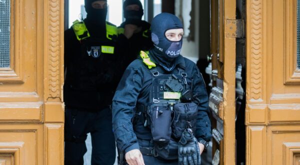 24 May 2023, Berlin: Police officers emerge from a building during a house search in Berlin-Kreuzberg. Police and public prosecutors searched 15 properties in seven German states as part of an investigation into members of the Last Generation. Photo: Christoph Soeder/dpa Photo: Christoph Soeder/DPA