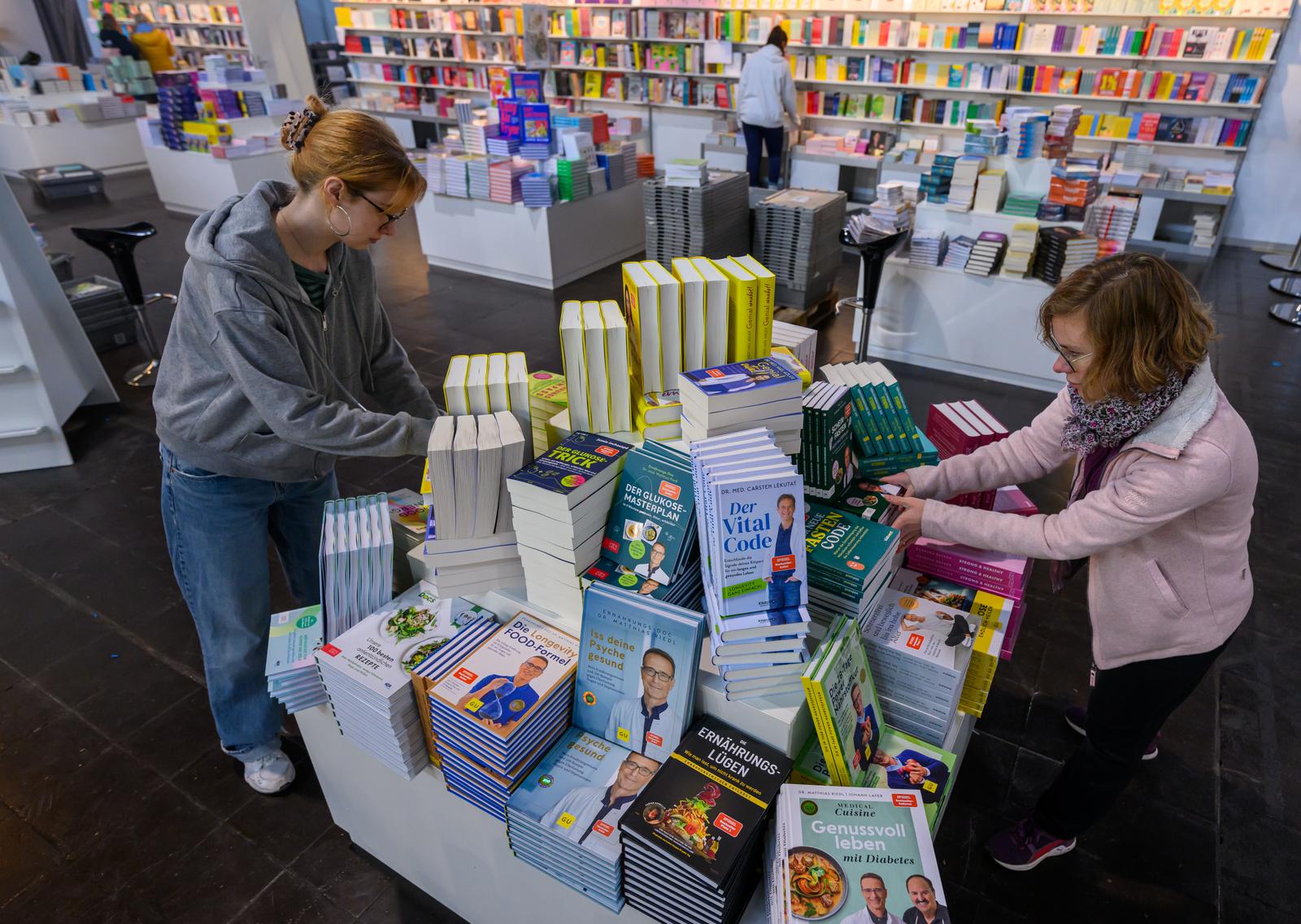 26 March 2025, Saxony, Leipzig: Employees of the bookshop prepare the stand at the Leipzig Book Fair. The book fair opens its doors to the public from Thursday (27.03.2025). Publishers will be presenting their new releases in this book spring until Sunday. This year's guest country is Norway. Photo: Hendrik Schmidt/dpa Photo: Hendrik Schmidt/DPA