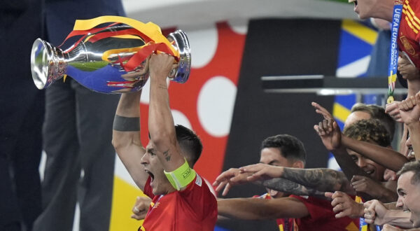 Spain's Alvaro Morata, left, lifts the trophy after Spain won the final match between Spain and England at the Euro 2024 soccer tournament in Berlin, Germany, Sunday, July 14, 2024. (AP Photo/Matthias Schrader)
