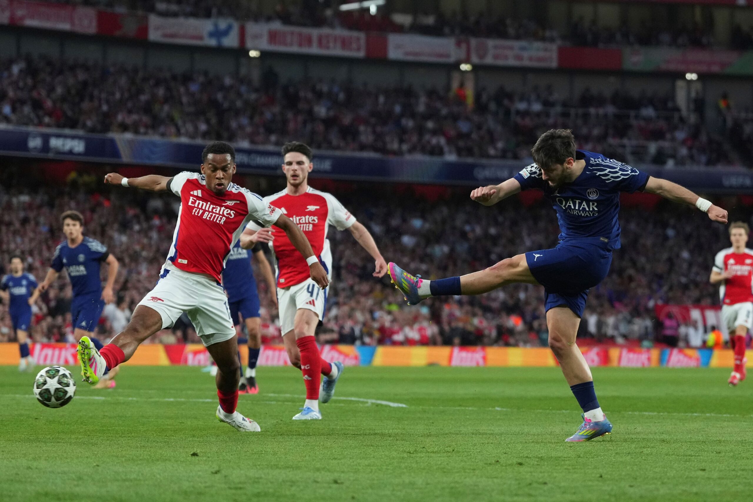 PSG's Khvicha Kvaratskhelia, right, attempts a shot at goal in front of Arsenal's Jurrien Timber, left, and Arsenal's Declan Rice during the Champions League semifinal first leg soccer match between Arsenal and Paris Saint-Germain at Emirates Stadium in London, England, Tuesday, April 29, 2025. (AP Photo/Kirsty Wigglesworth) Britan Soccer Champions League