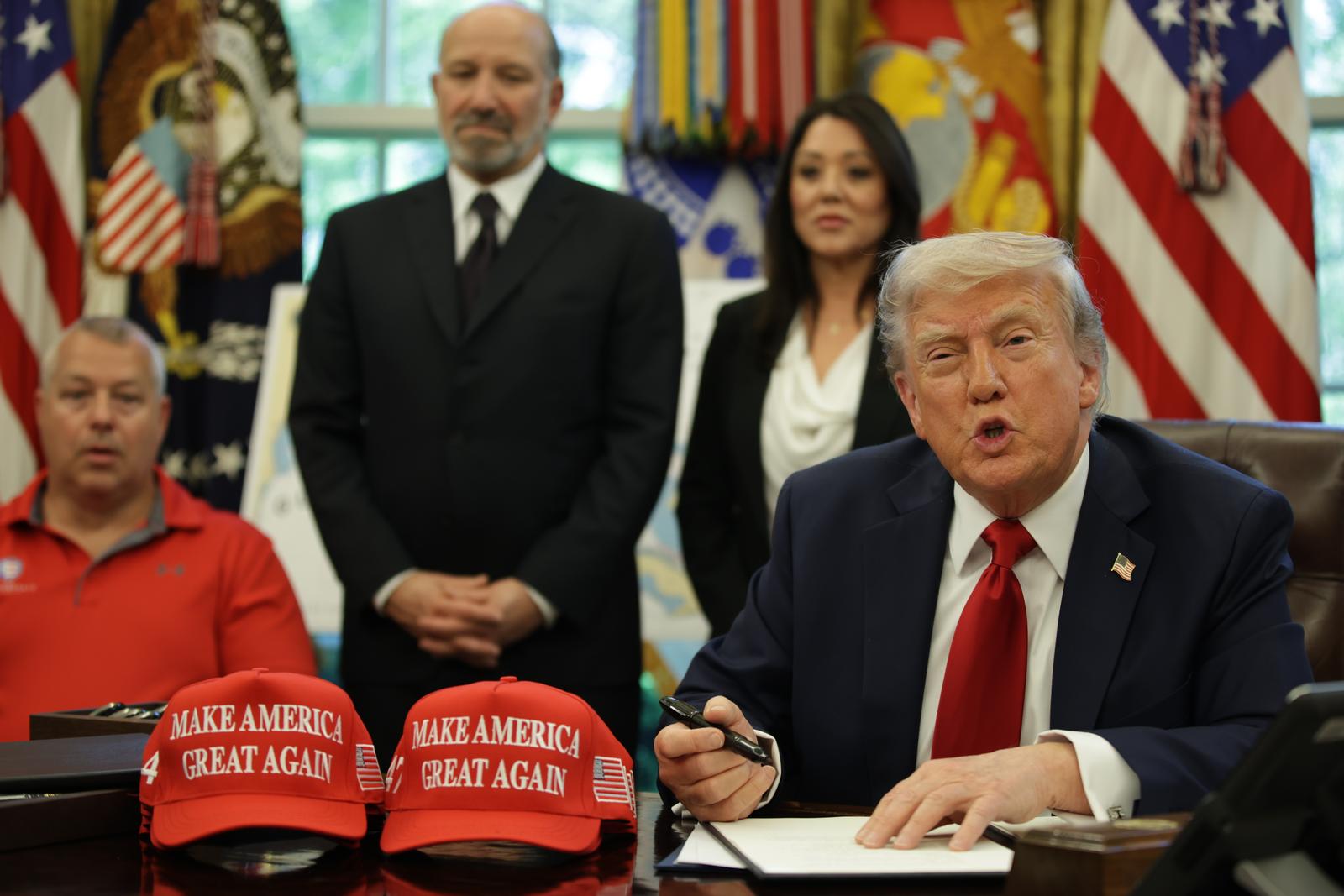 United States President Donald Trump signs executive orders in the Oval Office of the White House on April 23, 2025 in Washington, D.C. In the background: US Secretary of Commerce Howard Lutnick (L) and Secretary of Labor Lori Chavez-DeRemer (R). The orders signed today focus on education. Credit: Samuel Corum / Pool via CNP *** Local Caption *** 60950409