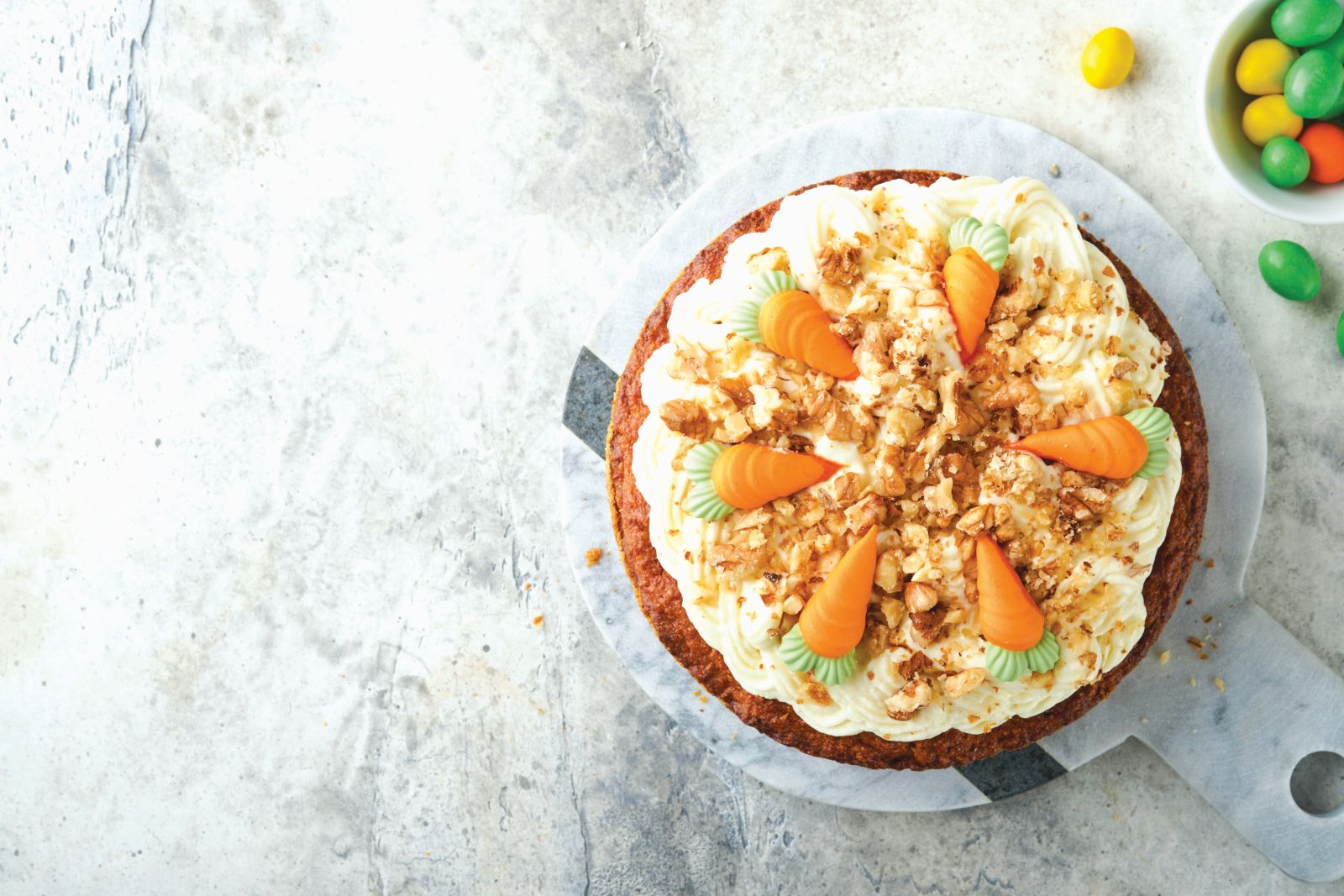 Easter Carrot cake with cream cheese frosting. Delicious carrot cake with walnut and cream cheese frosting on gray concrete background table for festive dinner. Traditional carrot cake. Easter food.