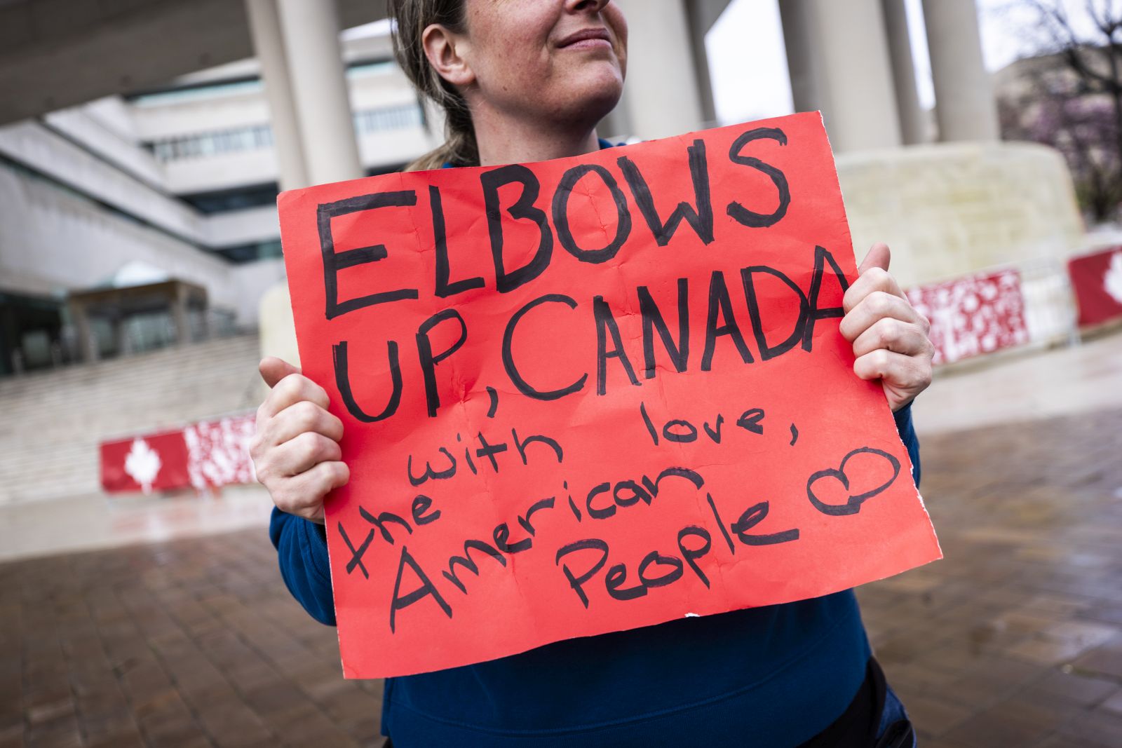 epa11986067 A supporter of Canadian solidarity stands outside the Canadian embassy to protest the Trump administration's calls to make Canada the 51st American state in Washington, DC, USA, 24 March 2025. Canadian Prime Minister Mark Carney warned on 23 March that US President Trump 'wants to break us so America can own us.'  EPA/JIM LO SCALZO