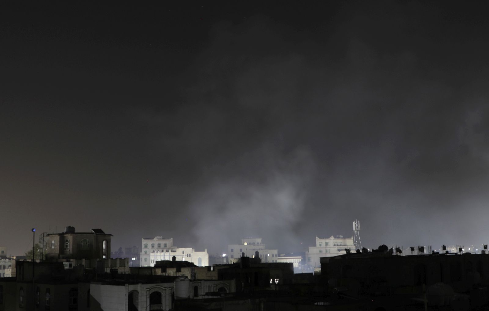 epa11991174 Smoke rises over buildings following US airstrikes, in Sana'a, Yemen, early 27 March 2025. The US military carried out a series of airstrikes early on 27 March, targeting multiple sites around Yemen's capital Sana'a, Houthi-affiliated Al Masirah TV reported.  EPA/OSAMAH YAHYA