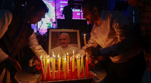epa12044743 People place candles next to a portrait during an inter faith memorial meeting to mourn the death of Pope Francis in New Delhi, India, 21 April 2025. Pope Francis died on 21 April 2025 at the age of 88, according to the Holy See. Born Jorge Mario Bergoglio in Buenos Aires, Argentina, on 17 December 1936, he was appointed leader of the Catholic Church on 13 March 2013, succeeding Pontiff Emeritus Benedict XVI.  EPA/RAJAT GUPTA