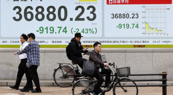 epa11994038 Pedestrians walk past a stock market indicator board in Tokyo, Japan, 28 March 2025. The Nikkei Stock Average closed at 37,120.33 yen, down 679.64 points from the previous day on the Tokyo stock market after briefly losing over 900 points, following concerns over US auto tariffs on Japanese automakers.  EPA/FRANCK ROBICHON