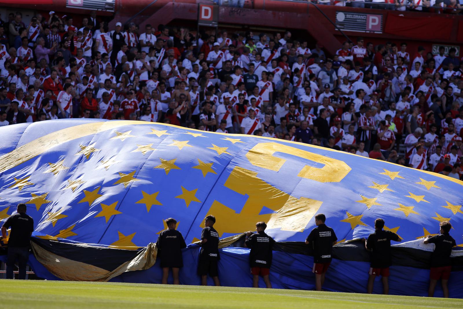 24 November 2018, Argentina, Buenos Aires: Soccer: South America, final Copa de Libertadores: River Plate - Boca Juniors, return match. Young employees unfold the flag of Boca Juniors in the stadium. Photo: Gustavo Ortiz/dpa /DPA/PIXSELL