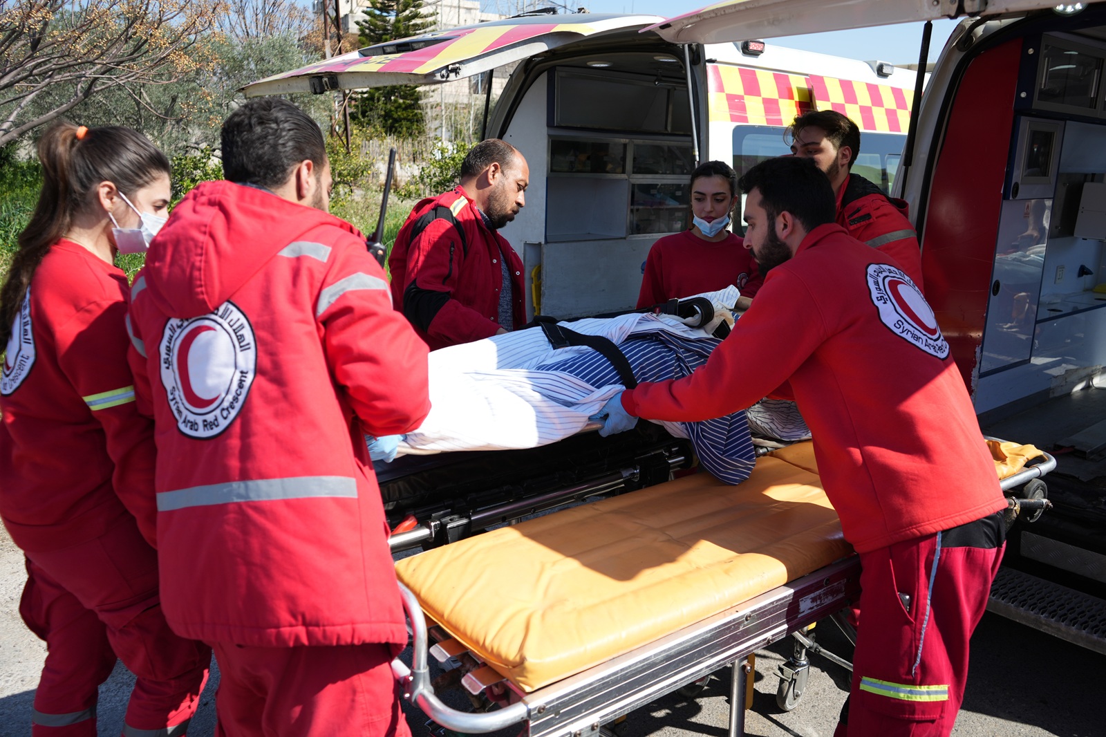 epa11956013 Members of the Syrian Red Crescent pick up people who got injured in the recent clashes between the Syrian government security forces and the supporters of the former regime, at the Russian Hmeimim airbase near Latakia, Syria on 11 March 2025. According to the UK-based Syrian Observatory for Human Rights (SOHR) more than 1,000 people were killed in two days of violence in the coastal province of Latakia.  EPA/AHMAD FALLAHA
