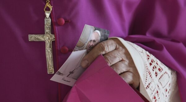 epa12049160 A prelate holds a picture of Pope Francis as he enters the atrium of St. Peter's Basilica where the body of Pope Francis will lie in state, Vatican City, 23 April 2025. Faithfull and well-wishers will be able pay their respects to the spiritual leader, who died on Easter Monday, 21 April 2025 aged 88, until his funeral on 26 April in the plaza in front of the basilica.  EPA/ANDREW MEDICHINI / POOL