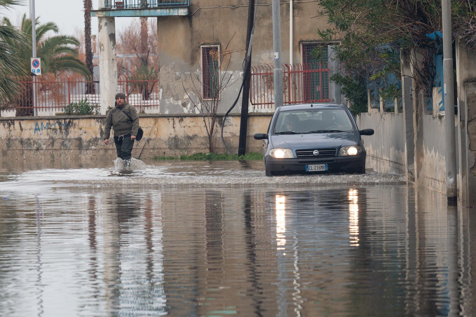 A man and a car try to cross a flooded road in Schiavonea, a seaside village flooded following heavy rains that hit all the coasts of Ionian Calabria. The coasts of Ionian Calabria, in southern Italy, were hit by a Mediterranean cyclone that brought devastation with strong winds and heavy rains, for some days in Calabria there has been a red alert from the civil protection for bad weather. This is also an effect of climate change. (Photo by Alfonso Di Vincenzo / ipa-agency.net/IPA/Sipa USA) Photo: IPA/SIPA USA