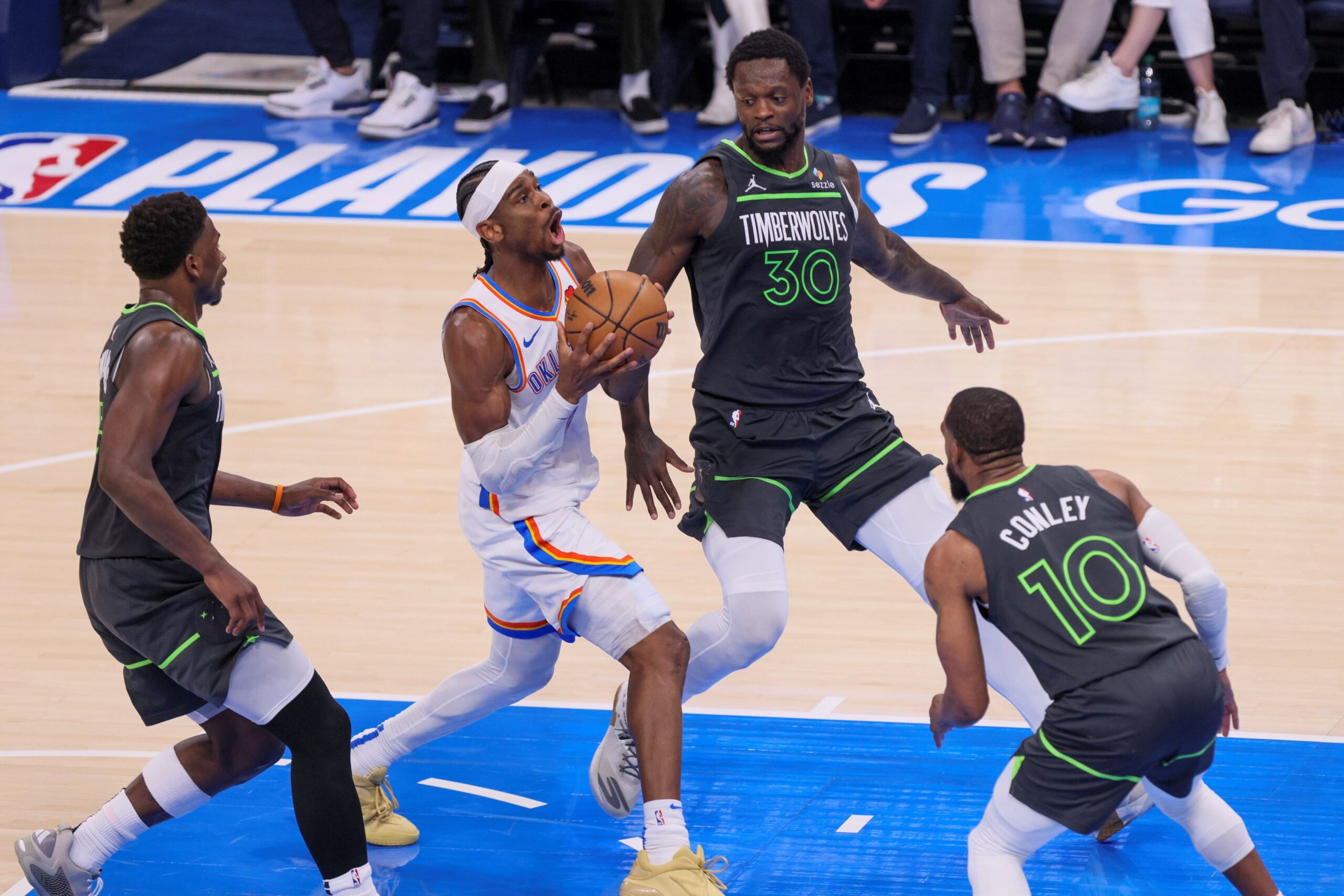 Oklahoma City Thunder guard Shai Gilgeous-Alexander, center, drives to the basket against Minnesota Timberwolves guard Anthony Edwards, left, forward Julius Randle (30) and guard Mike Conley (10) during the first half of Game 1 of an NBA basketball Western Conference Finals playoff series Tuesday, May 20, 2025, in Oklahoma City. (AP Photo/Nate Billings) Timberwolves Thunder Basketball