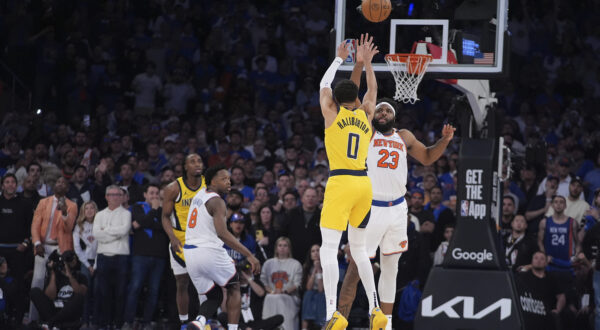 Indiana Pacers guard Tyrese Haliburton (0) shoots a 2-point shot against New York Knicks center Mitchell Robinson (23) to tie the score at the end of regulation in Game 1 of the NBA basketball Eastern Conference final, Wednesday, May 21, 2025, in New York. (AP Photo/Frank Franklin II)