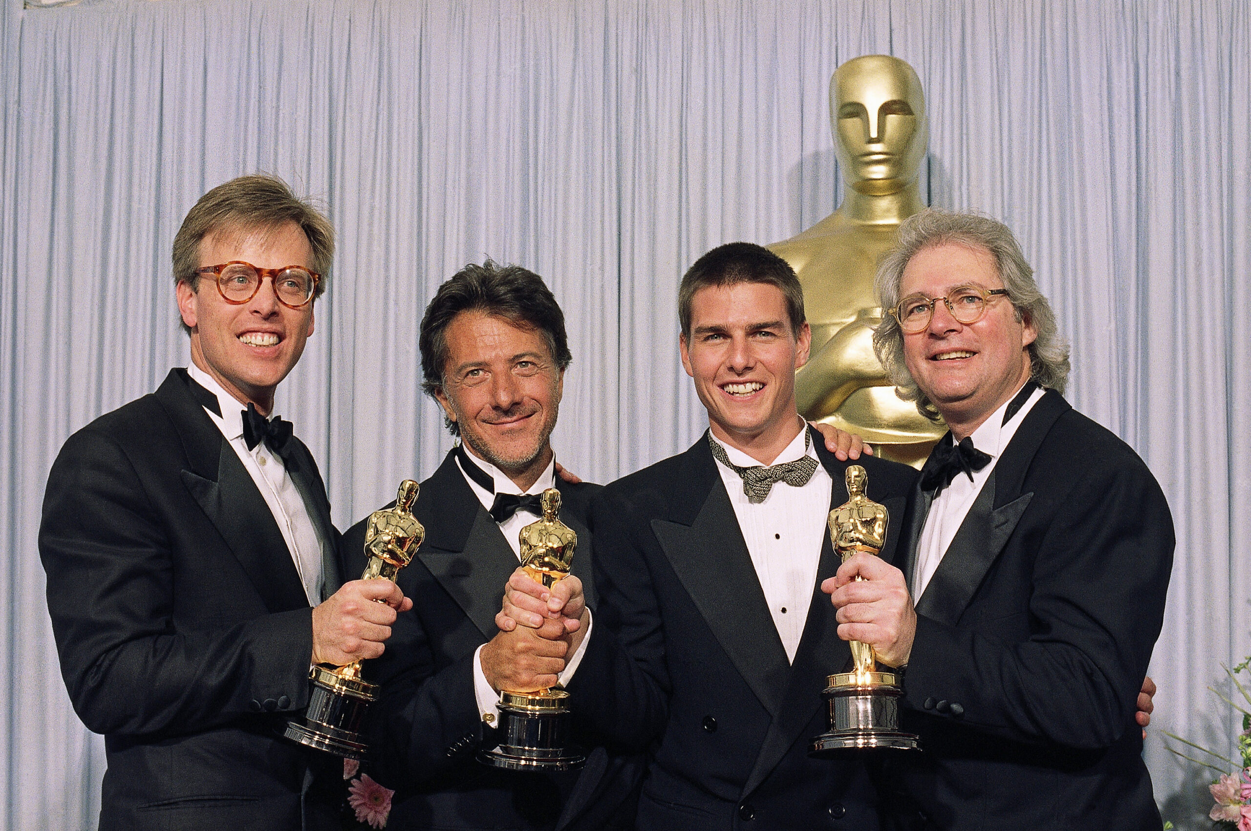 The principals of this years' best film, from left, Mark Johnson, Dustin Hoffman, Tom Cruise and Barry Levinson are all smiles as they display their "Oscars"  in Los Angeles, March 29, 1989 after "Rain Man" was named best film. This was the 61st Annual Academy Awards.   (AP Photo)