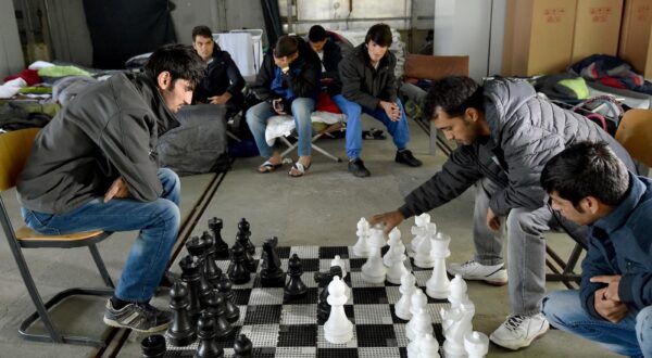 Refugees from Afghanistan play chess in an emergency shelter in Eisenhuettenstadt, Germany, 17 October 2015. 17 winterproof halls for some 1,000 refugees will be erected on the former grounds of the German federal police. Photo:?Bernd Settnik/dpa/DPA/PIXSELL