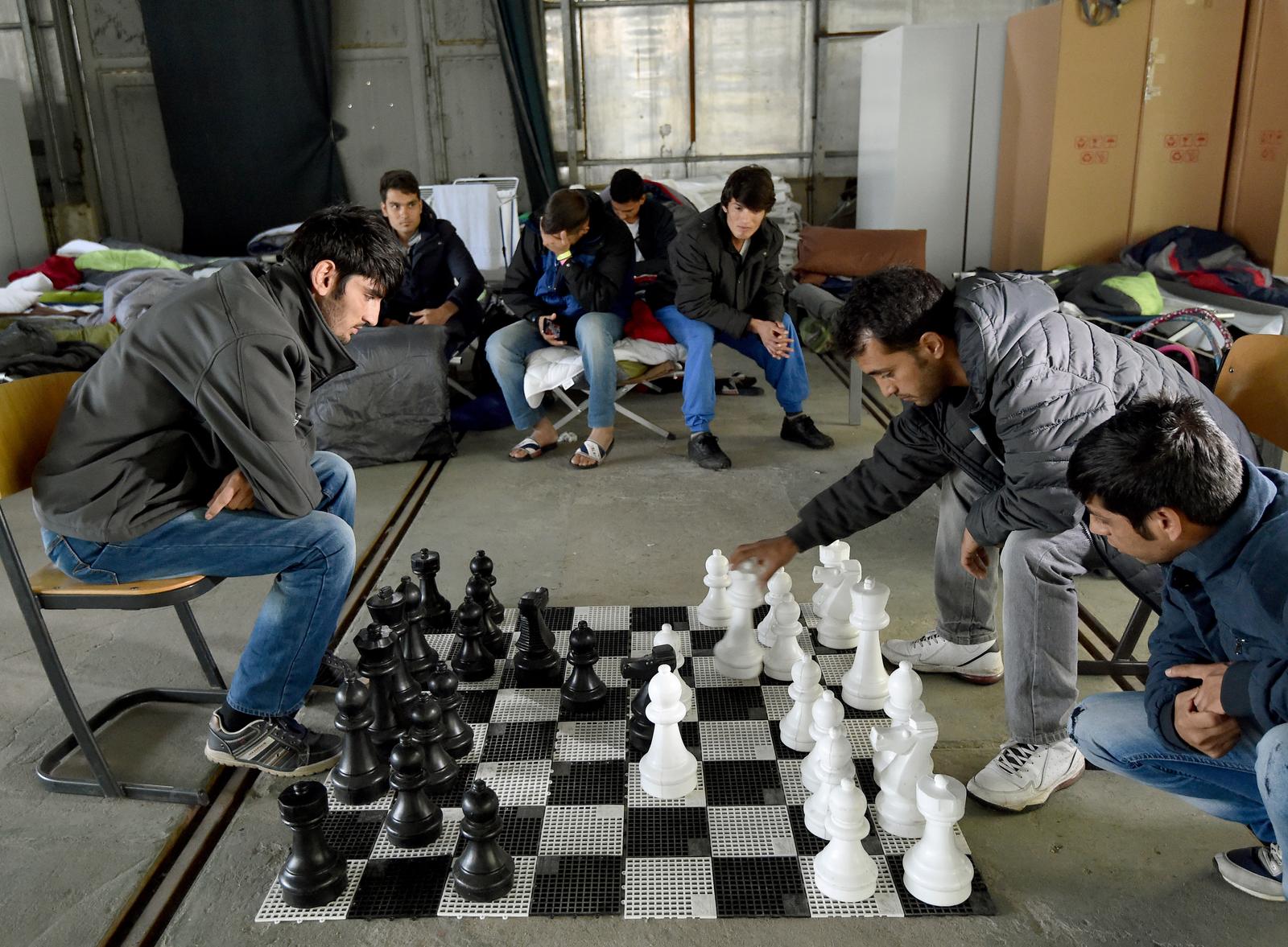 Refugees from Afghanistan play chess in an emergency shelter in Eisenhuettenstadt, Germany, 17 October 2015. 17 winterproof halls for some 1,000 refugees will be erected on the former grounds of the German federal police. Photo:?Bernd Settnik/dpa/DPA/PIXSELL