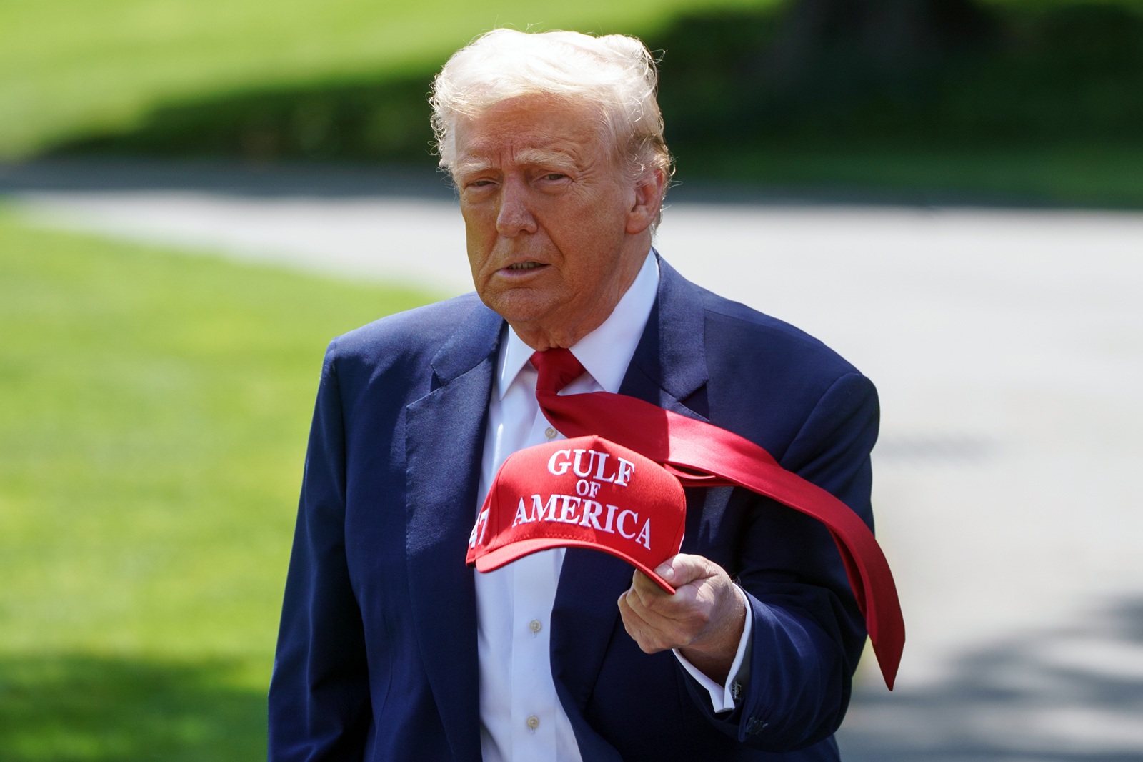 epa12063428 US President Donald Trump walks holding a 'Gulf of America' baseball cap on the South Lawn of the White House before departing to Michigan, in Washington, DC, USA, 29 April 2025. President Trump is due to host a rally in Michigan to mark 100 days since the start of his second term.  EPA/WILL OLIVER