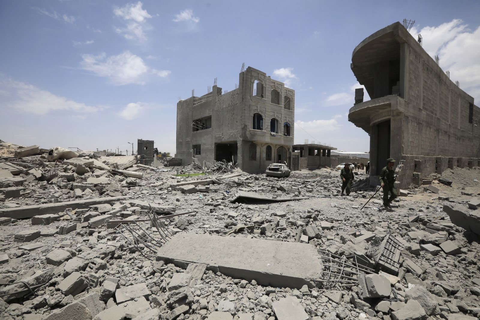 epa12058479 Yemeni soldiers walk amid the rubble as they inspect a damaged area after US airstrikes targeted a neighborhood in Sana'a, Yemen, 27 April 2025. At least two people were killed and 10 others wounded following overnight US airstrikes, which struck two neighborhoods of Sana'a, according to Houthi-run Al-Masirah TV.  EPA/YAHYA ARHAB