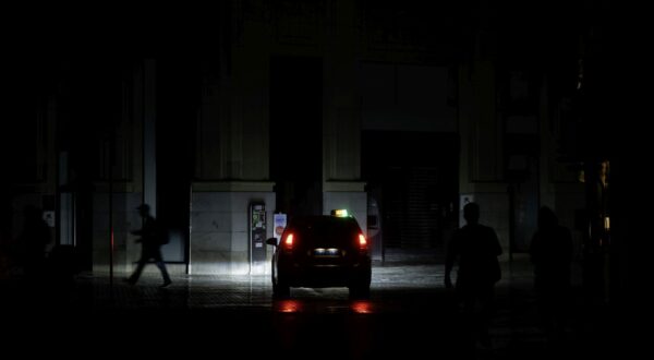 epaselect epa12061674 A person walks down a downtown street during a power outage in Málaga, Spain, 29 April 2025.  EPA/Jorge Zapata