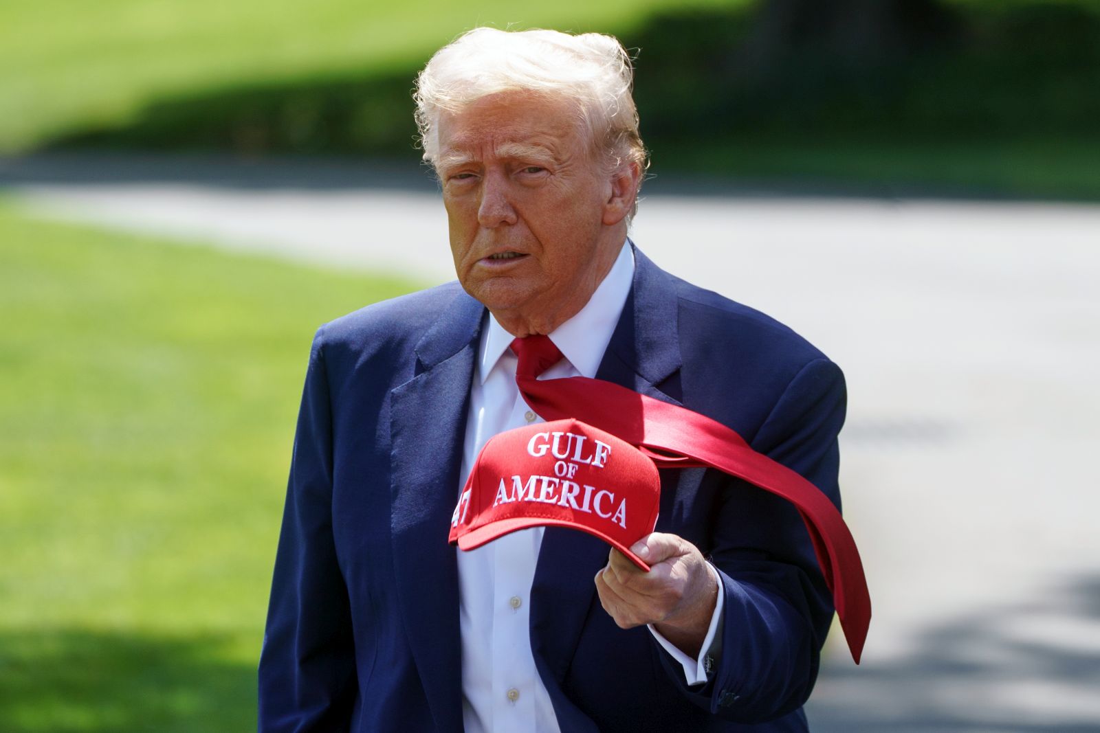 epa12063428 US President Donald Trump walks holding a 'Gulf of America' baseball cap on the South Lawn of the White House before departing to Michigan, in Washington, DC, USA, 29 April 2025. President Trump is due to host a rally in Michigan to mark 100 days since the start of his second term.  EPA/WILL OLIVER